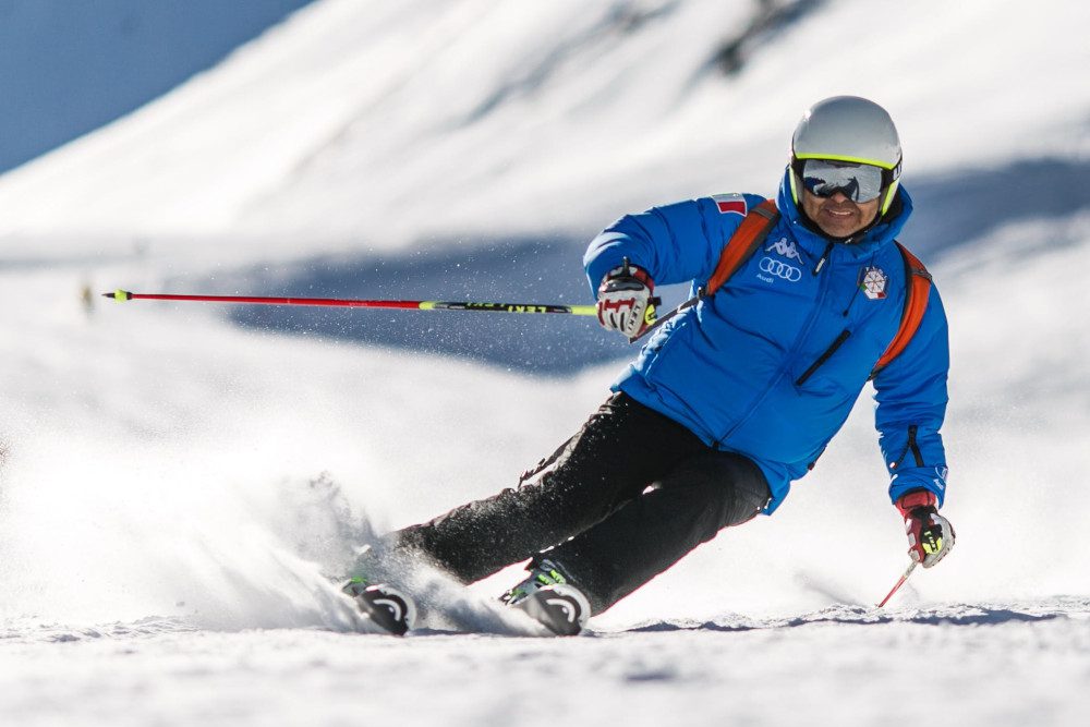 man in blue jacket skiing